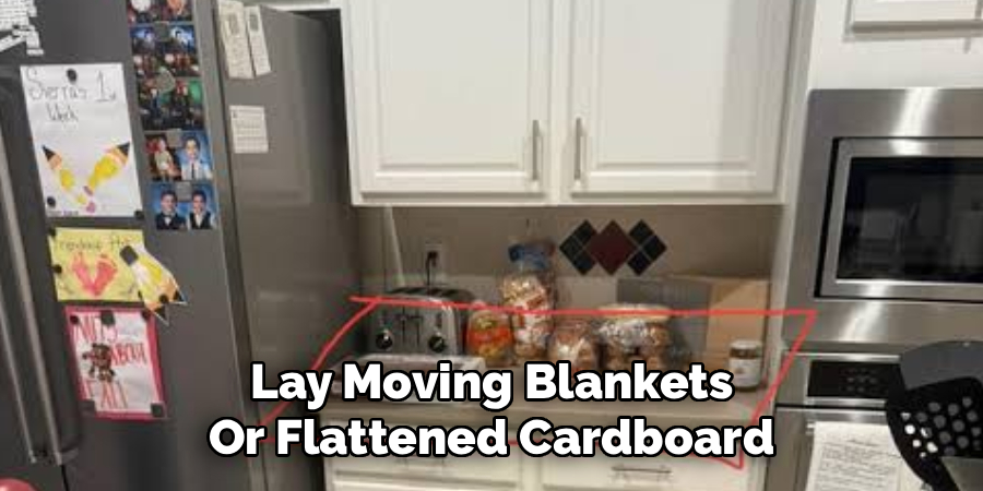 Lay Moving Blankets
Or Flattened Cardboard